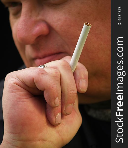 Close up of a man with a cigarette in his hand. Close up of a man with a cigarette in his hand