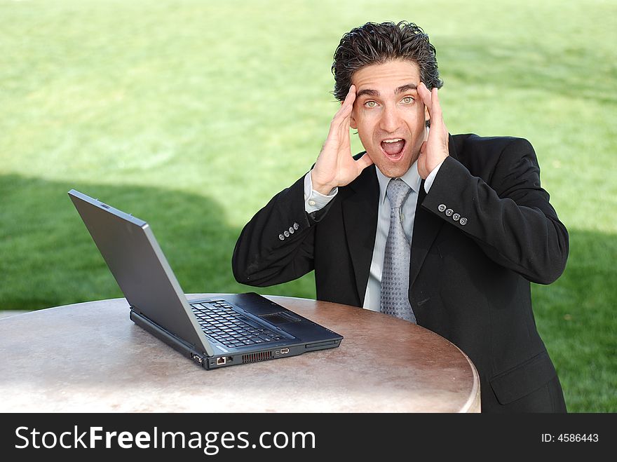 Shocked and suprised businessman looking at his laptop. Shocked and suprised businessman looking at his laptop