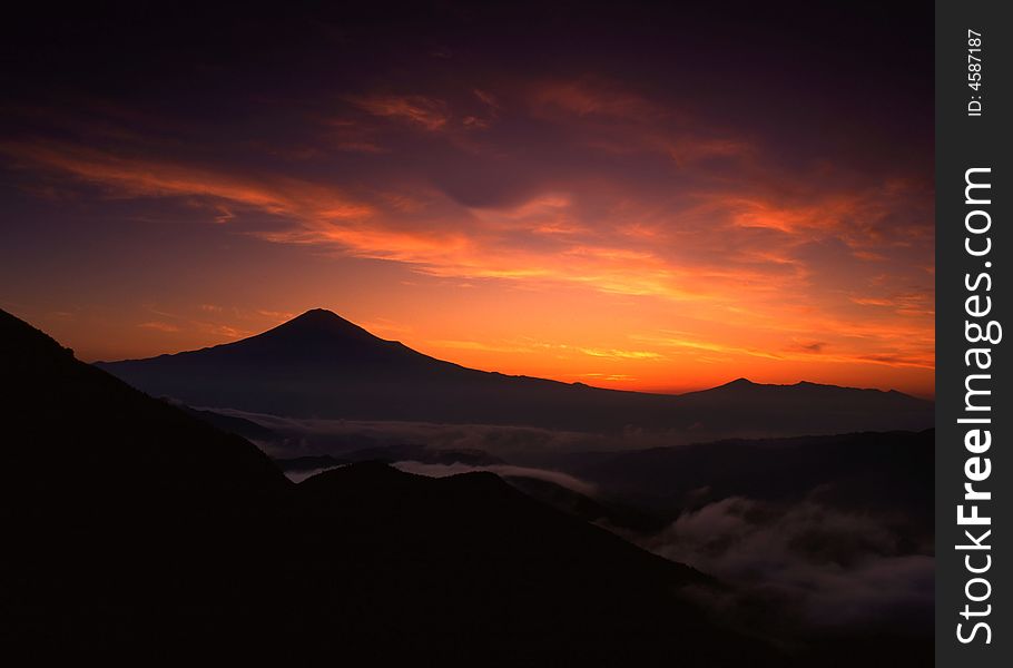 Dramatic and colorful sunrise over the silhouette of Mt. Fuji. Dramatic and colorful sunrise over the silhouette of Mt. Fuji