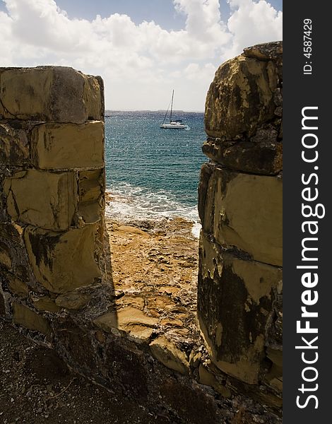 Boat seen through ruins of English fort on tropical island of Antigua. Boat seen through ruins of English fort on tropical island of Antigua