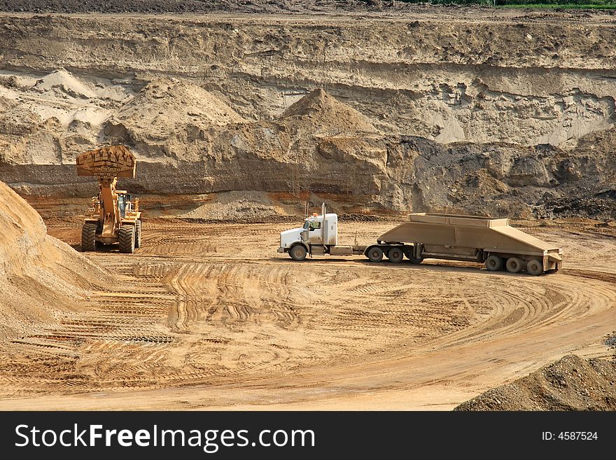 A gravel truck preparing to load in an open gravel pit. A gravel truck preparing to load in an open gravel pit
