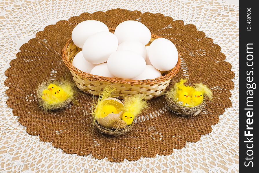 A basket of eggs and a group of easter chickens