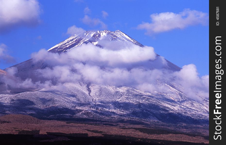 Mount Fuji enshrouded in clouds and blue sky. Mount Fuji enshrouded in clouds and blue sky