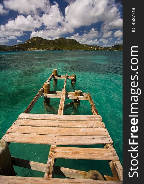 Damaged dock over turquoise waters on tropical island. Damaged dock over turquoise waters on tropical island