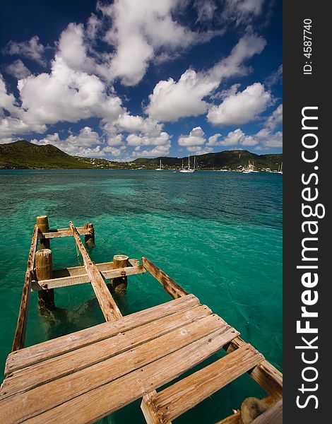 Damaged dock over turquoise waters on tropical island. Damaged dock over turquoise waters on tropical island