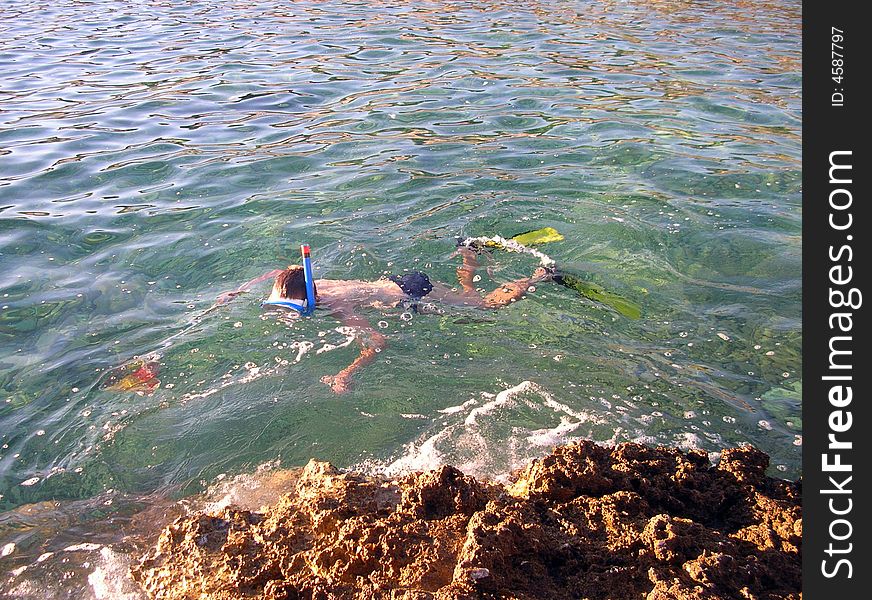 A snorkeling boy with net for take fish - in Croatia sea
