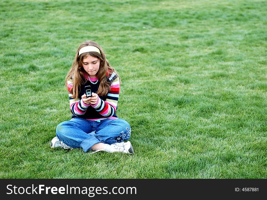 Young blond girl in the park and cell phone. Young blond girl in the park and cell phone