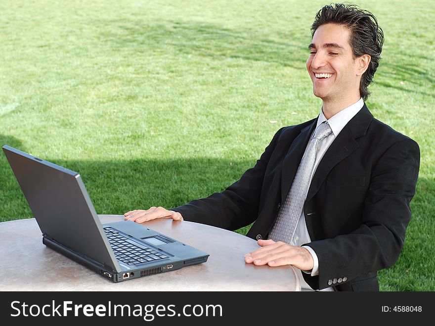 Confident and successful young adult businessman sitting at an outdoor environtment. Confident and successful young adult businessman sitting at an outdoor environtment