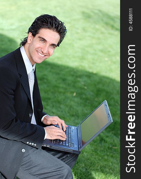 Happy businessman looking at his laptop