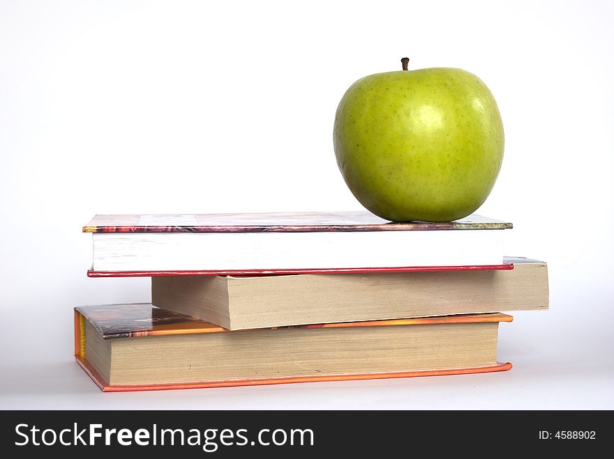 Green apple and stack of books