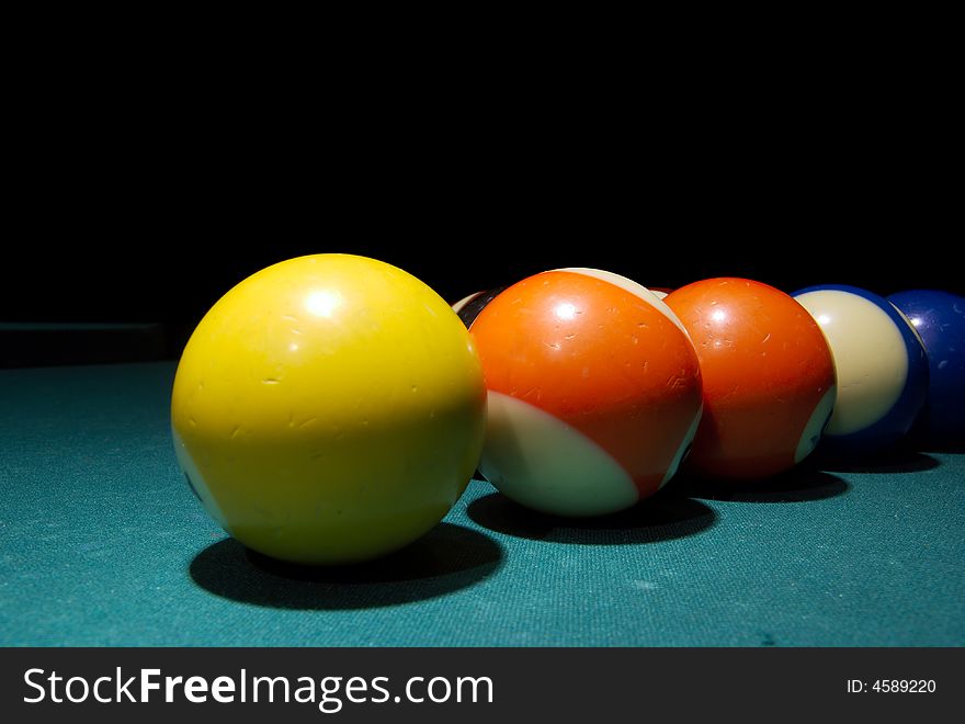 Billiard balls on the green table isolated black background