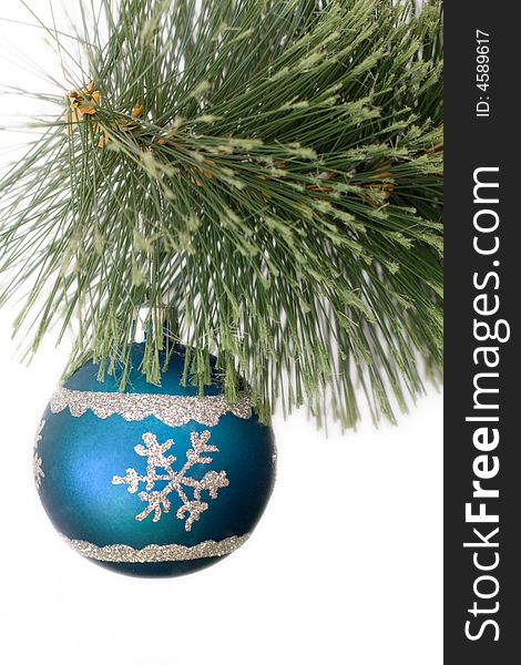 A blue christmas ball hanging on the pine branch