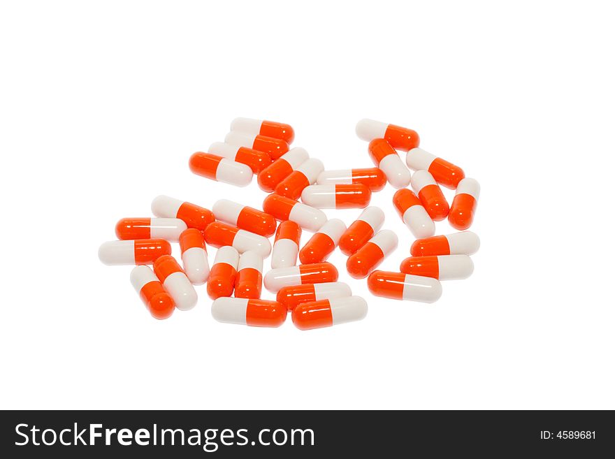 Some white-orange pills situated isolated over white background