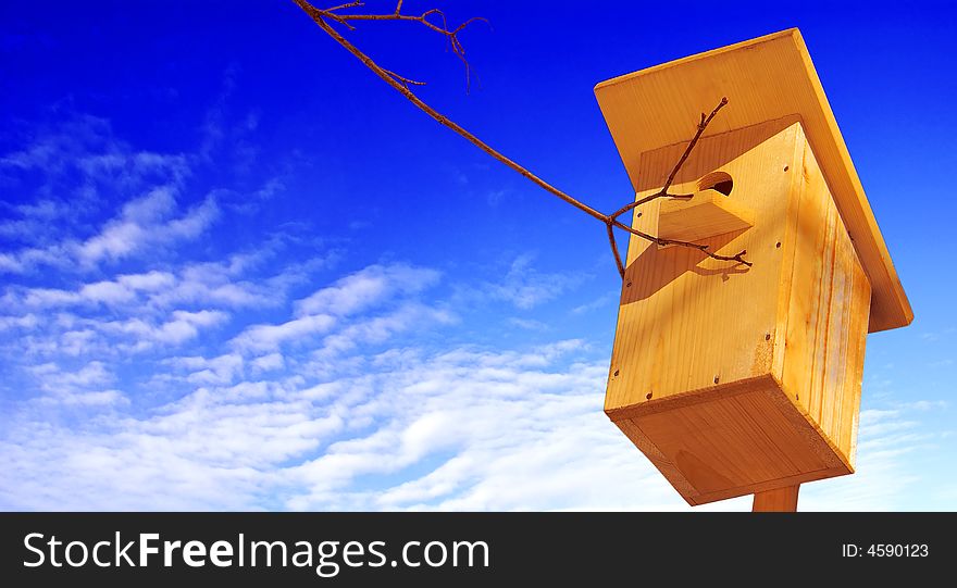 A new wooden starling house on a background of the bright blue sky. A new wooden starling house on a background of the bright blue sky.