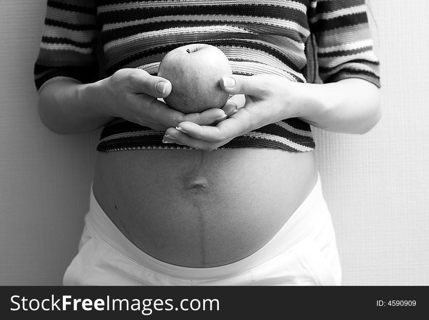 Grayscale image of pregnant body. Focus on hands