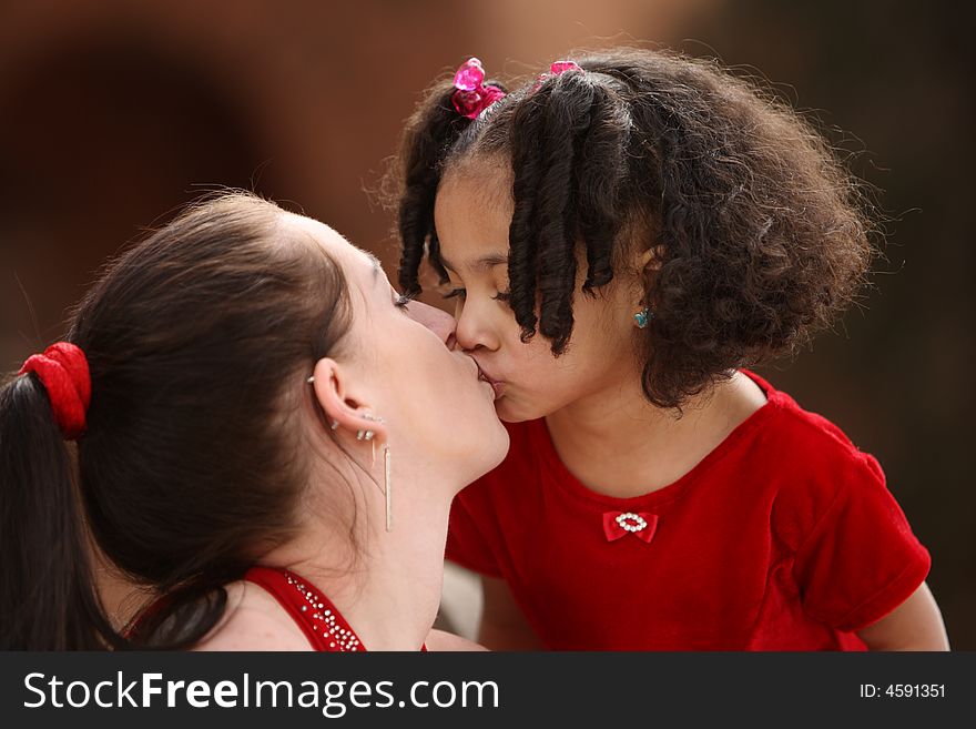 Beautiful multiracial child with afro hairstyle playing with her mother. Beautiful multiracial child with afro hairstyle playing with her mother
