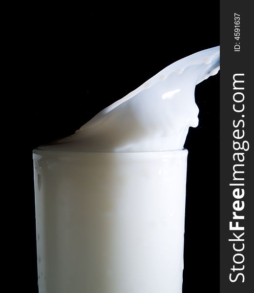 Glass of milk on a black background