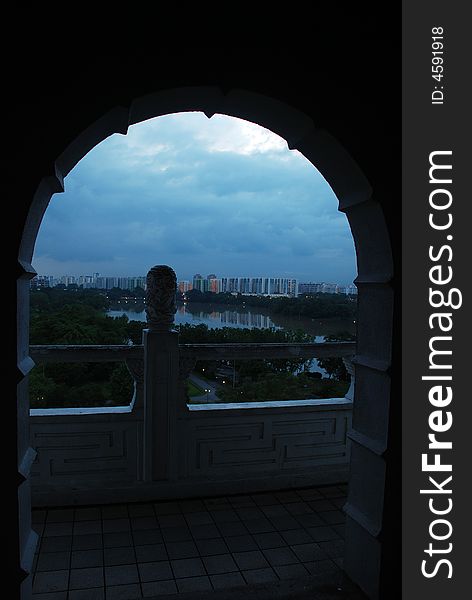 A view of building and sky through an arch door. A view of building and sky through an arch door