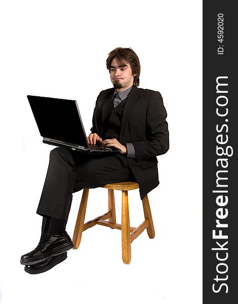A young businessman sitting on a chair and working on his computer