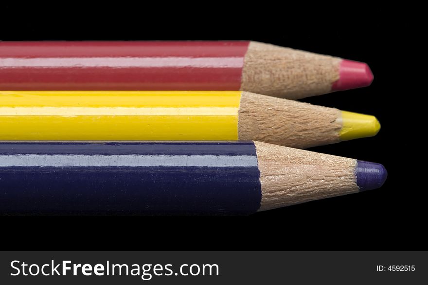 A row of colored pencils shot against a black background. Includes clipping path.