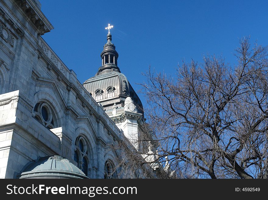 A picture of a steeple with cross reaching into sky