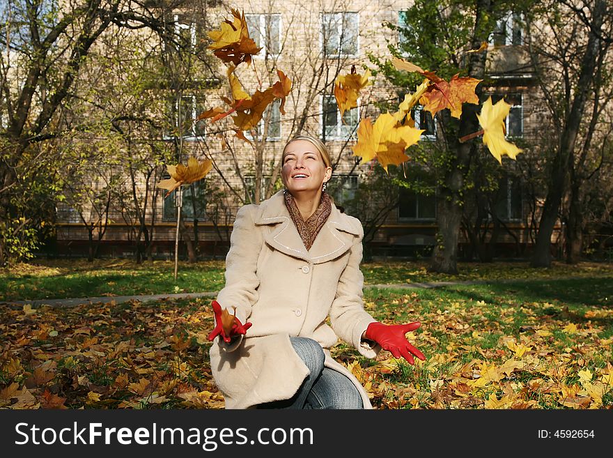 Happy woman with a throw leafs. Happy woman with a throw leafs