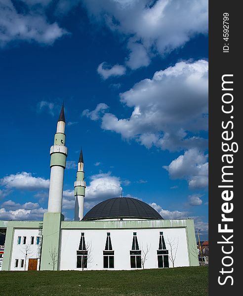 Mosque with two minarets under the blue and cloudy sky