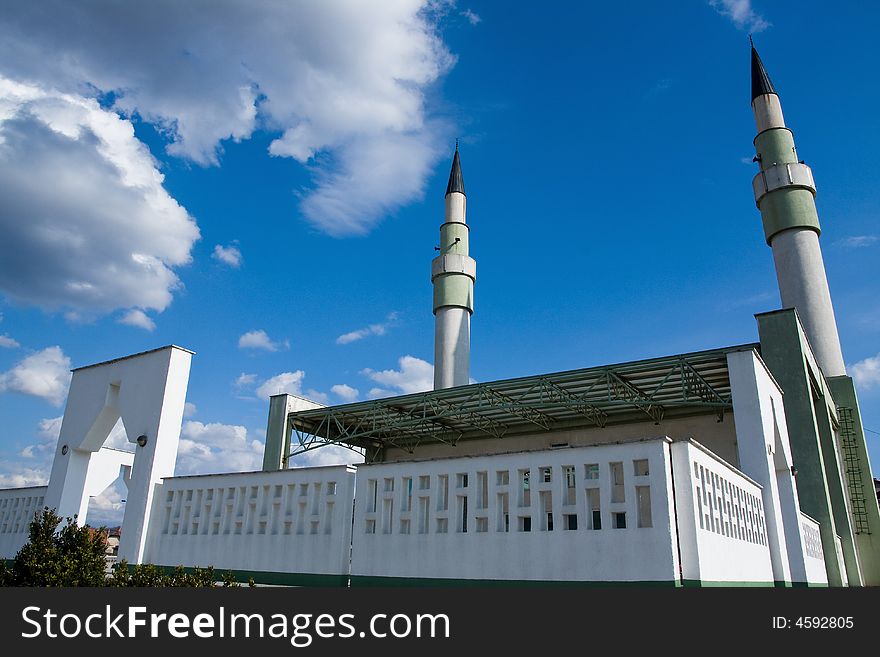 Mosque with two minarets on the sunny day under the blue sky