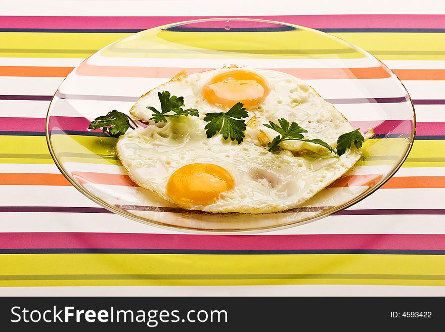 Food series: fried eggs with parsley on the glassy plate. Food series: fried eggs with parsley on the glassy plate