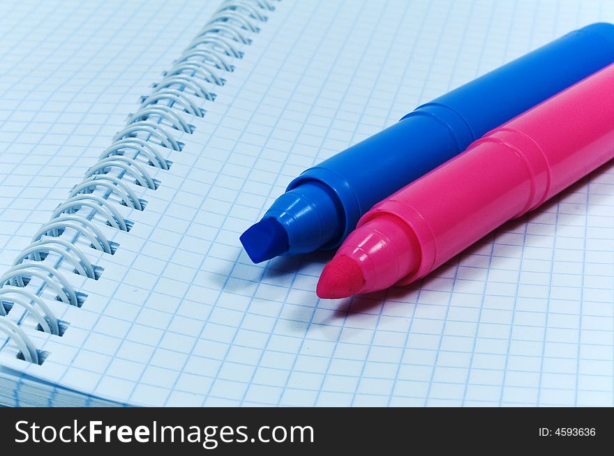 Two colored markers over notebook