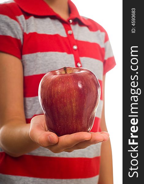 A child offering a ripe red apple in an open hand on a white background. A child offering a ripe red apple in an open hand on a white background