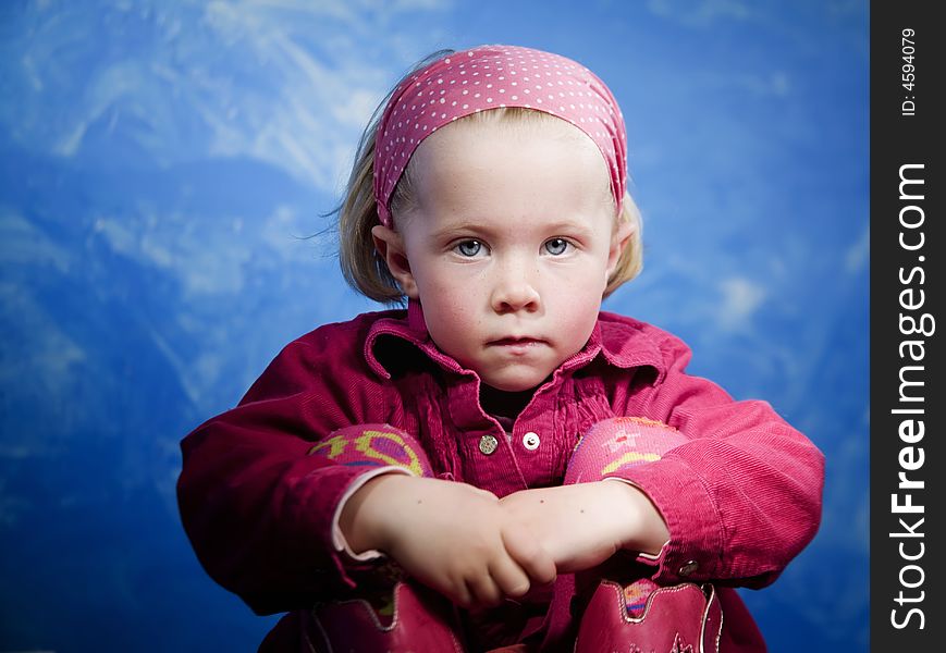 Little girl in studio in front of a blue wall. Little girl in studio in front of a blue wall