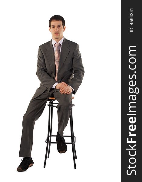 Young businessman sits on stool isolated on white
