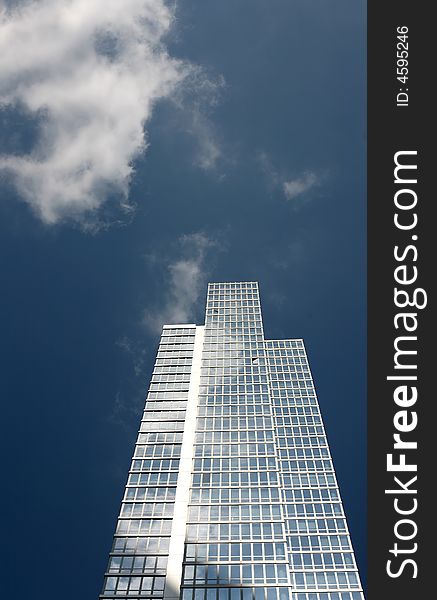 New office building against blue sky with clouds reflections in the windows, New York city