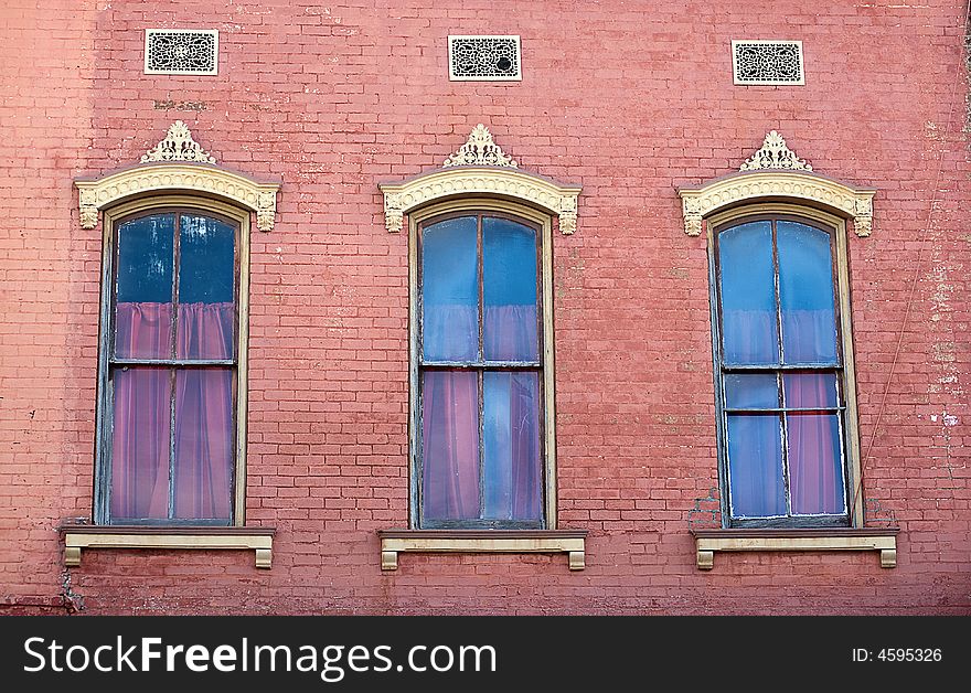 Three Windows And Pink Brick