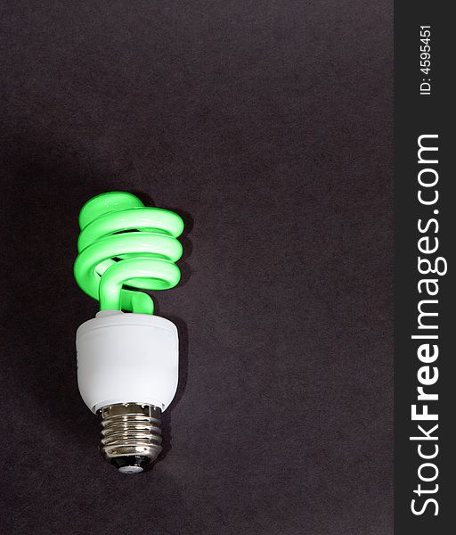 A compact florescent light bulb colored green to represent being green for our planet. A compact florescent light bulb colored green to represent being green for our planet