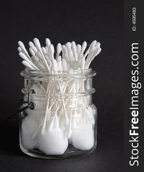 An old jar filled with cotton balls and swabs. An old jar filled with cotton balls and swabs