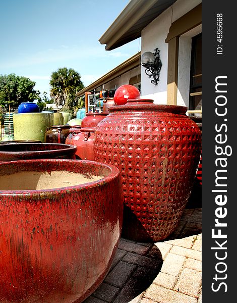 A small collection of red clay pots outside of a pottery store.