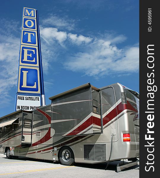 Motel sign, blue sky and tour bus