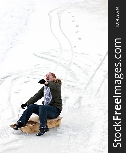 Excited woman, sliding downhill on a sledge.