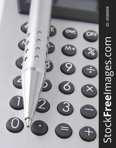 Silver calculator and metal pen. Silver calculator and metal pen