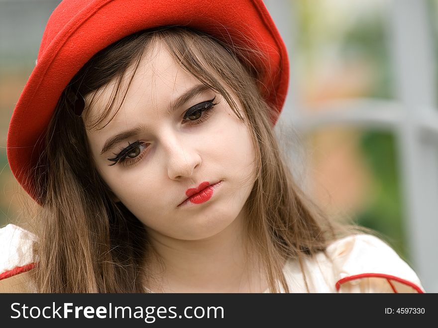 The young beautiful girl in a red cap
