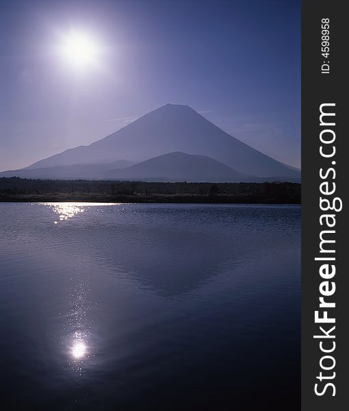 The Sunrise winter view of Mount Fuji with mist and reflections in a lake. The Sunrise winter view of Mount Fuji with mist and reflections in a lake