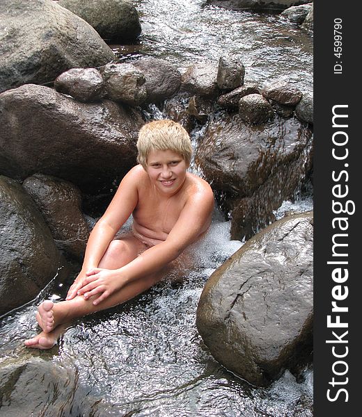 Smiling blond boy in a mountain river. Smiling blond boy in a mountain river