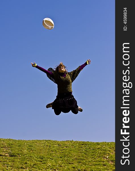 Happy young woman jumping over the grass