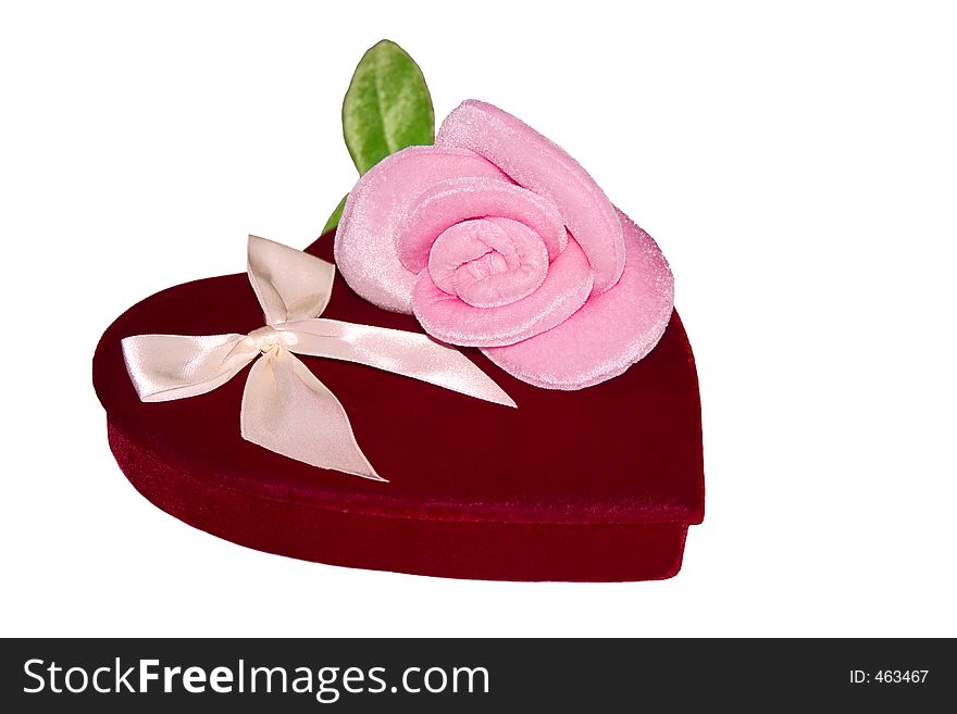 Red velvet heart shaped candy box with a soft, fuzzy, stuffed pink rose sitting on top. Red velvet heart shaped candy box with a soft, fuzzy, stuffed pink rose sitting on top.