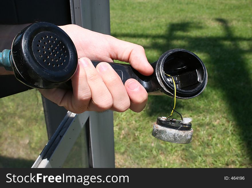 Hand holding broken pay phone