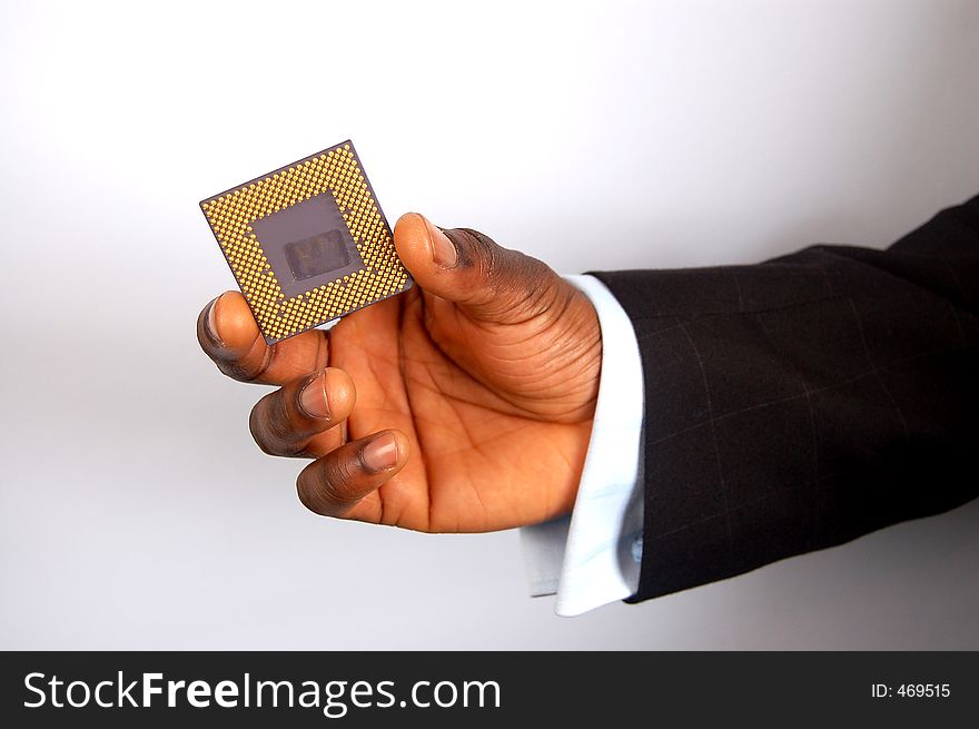 This is an image of a black business man holding a microprocessor chip. This is an image of a black business man holding a microprocessor chip.