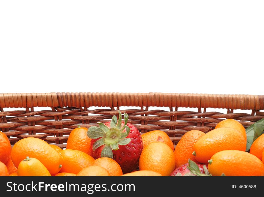 A lot of kumquats an strawberry in a basket isolated on white background