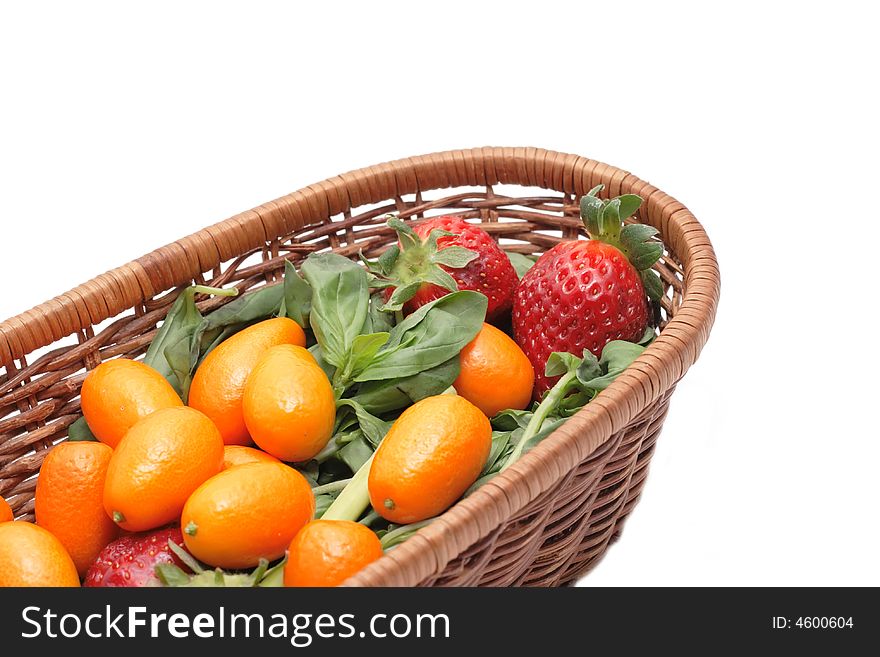 A lot of kumquats and strawberry in a basket isolated on white background